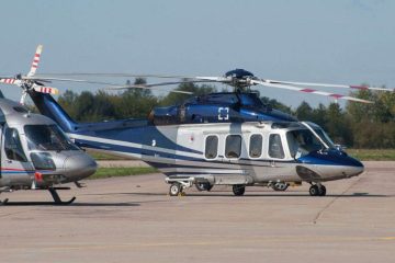 Şehir manzarası üzerinde uçan bir kiralık helikopter ve içindeki yolcular.