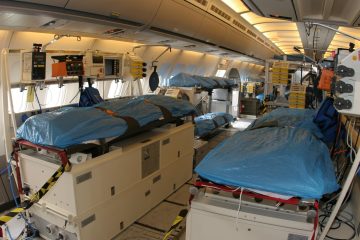 Havalimanında hastayı taşıyan ambulans jete doğru ilerleyen sağlık ekibi