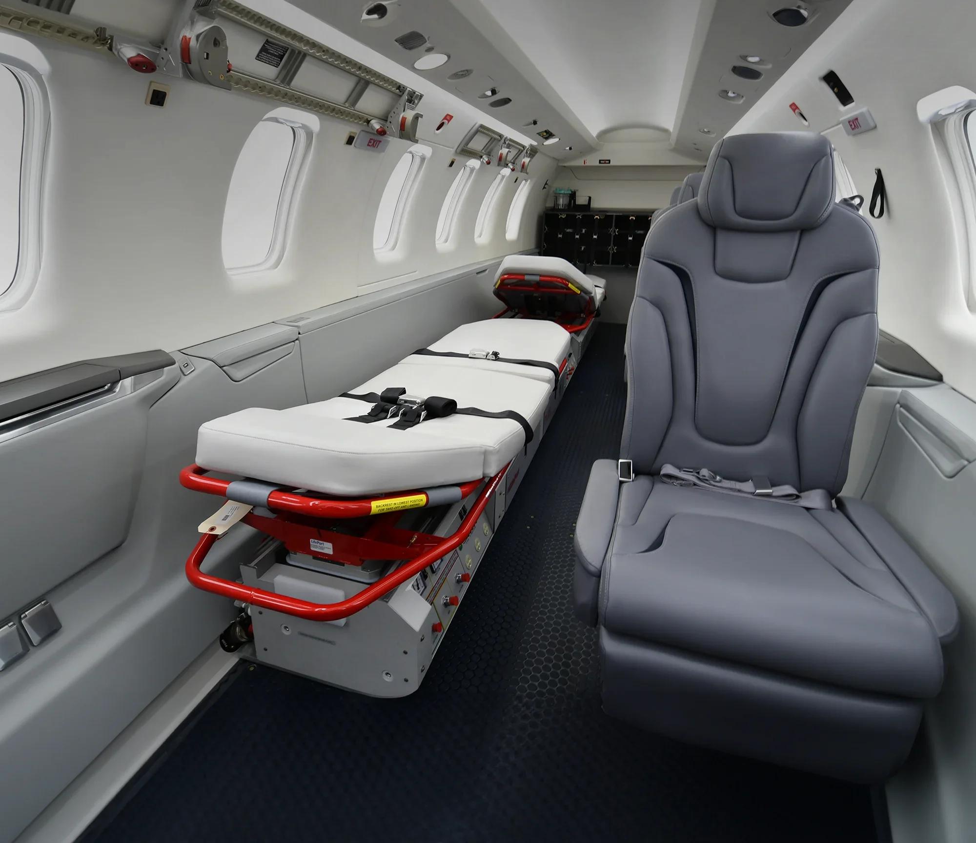 Havalimanı pistinde kalkışa hazırlanan bir ambulans uçak, içinde acil tıbbi ekipman ve hasta taşıyan sağlık personeliyle birlikte.