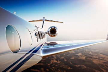 Gökyüzünde seyir halinde lüks bir özel jet, arka planda Londra silueti.