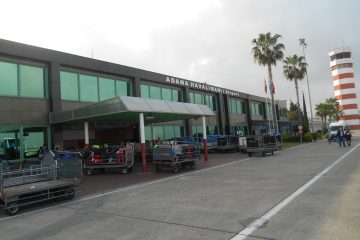 Adana Şakirpaşa Havalimanı terminal binası ve apron alanında park etmiş uçaklar.