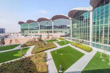 Amman Kraliçe Aliye Uluslararası Havalimanı terminal binası, giriş bölümü ve önündeki yolcu ve araç trafiğiyle birlikte görülüyor.