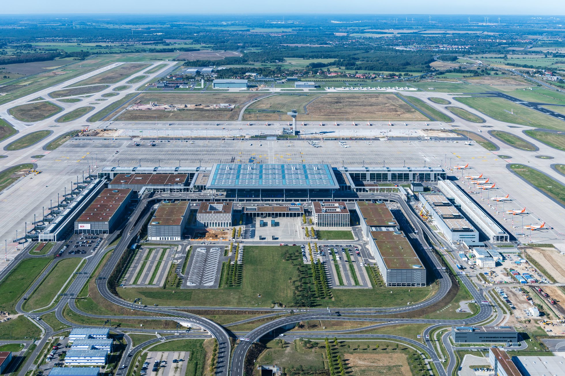 Berlin Brandenburg Havaalanı terminali ve apronunda park halinde bekleyen modern özel jet uçağı