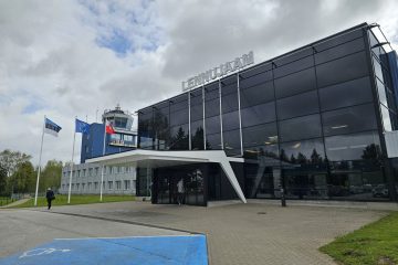 Estonya Tartu Havalimanı’nda (TAY) küçük terminal binası ve apron bölgesinde park etmiş yolcu uçağı