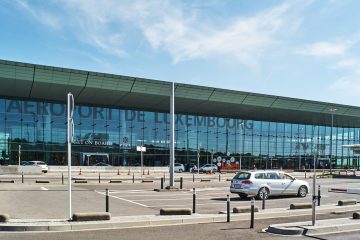 Cam cephesiyle Lüksemburg-Findel Havalimanı terminal binası ve önünde park halinde bekleyen yolcu uçakları