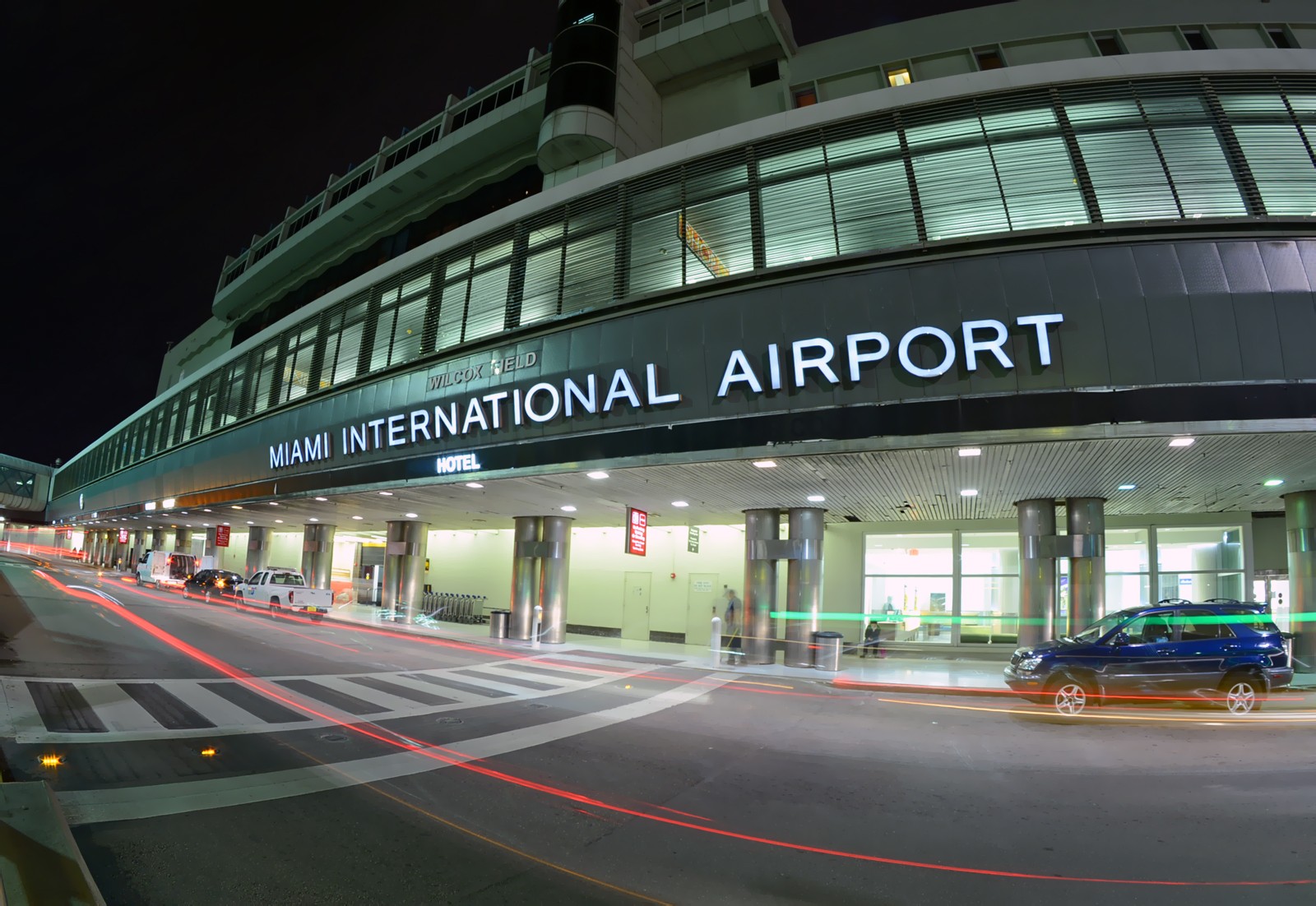 Miami Havalimanı’nda (MIA) geniş terminal binası, apron üzerindeki yolcu uçakları ve arka planda Miami silüeti