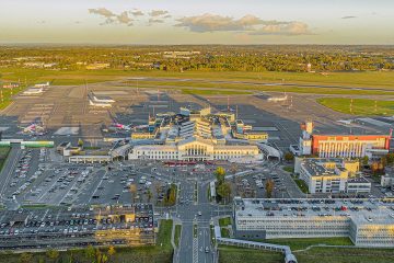 Vilnius Havalimanı’nda apron üzerinde park halinde bir özel jet ve terminal binası manzarası.