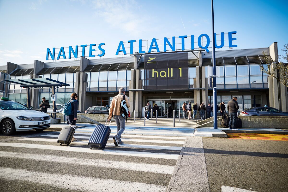 Nantes Havalimanı’nda (NTE) terminal binası önünde park etmiş yolcu uçağı ve apron üzerinde hareket eden yolcular